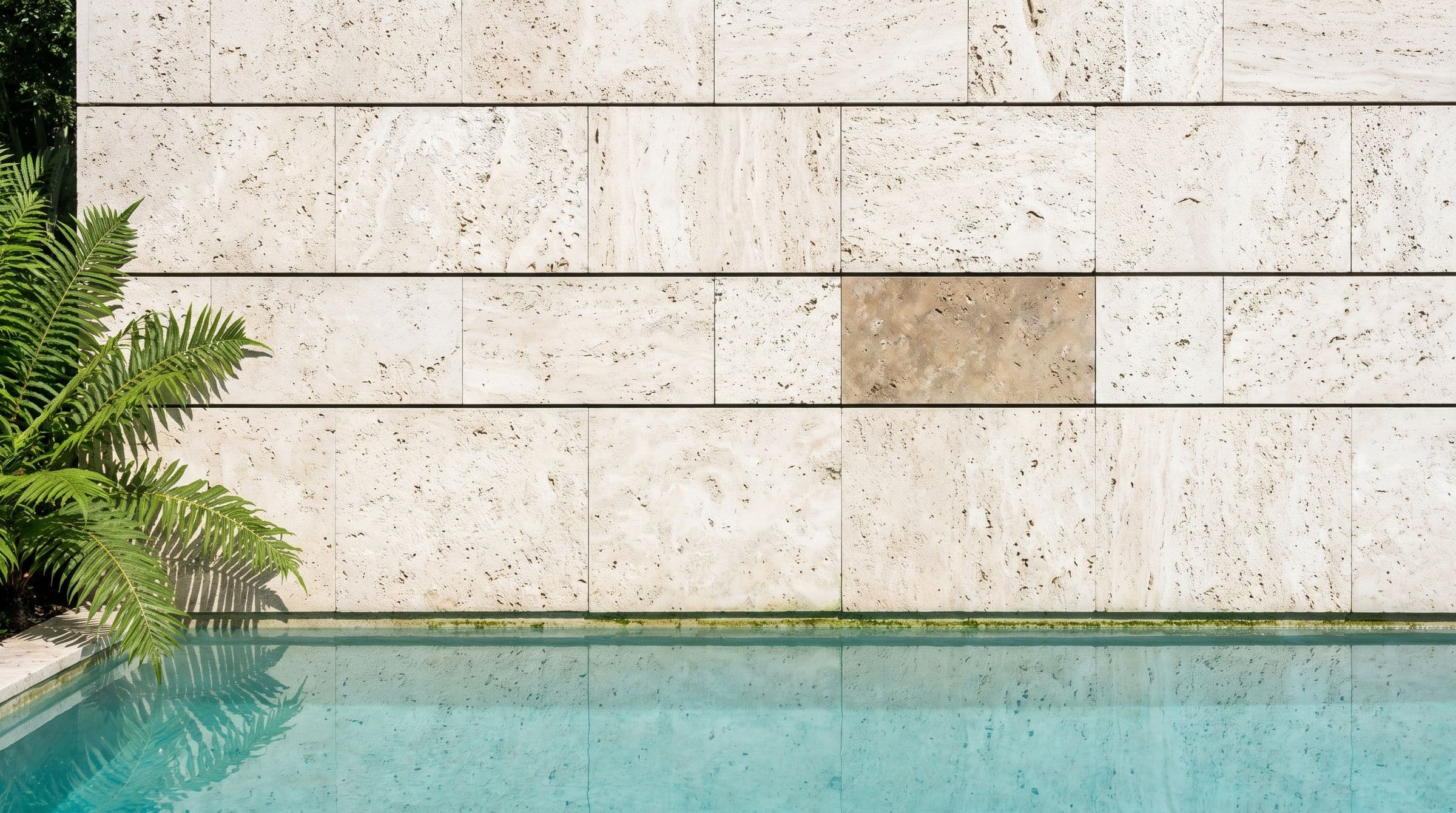 A finished travertine wall above still water